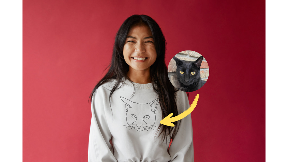 Joyful asian girl wearing a custom embroidered hoodie with line art made from a photo of her cat.