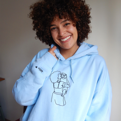 BLM woman wearing her custom embroidered blue hoodie with a portrait of her holding her dog in the arms.